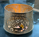 Decorative glass candle holder with intricate patterns on a dark background