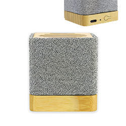 A mini Bluetooth speaker with a gray fabric finish on the upper part and a bamboo base.