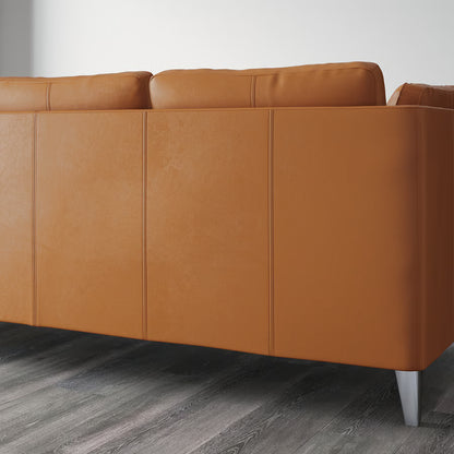 Brown leather sofa on a wooden floor with a white wall background