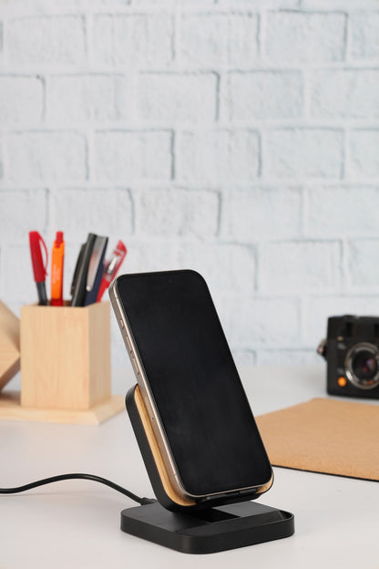 Black smartphone on a charging stand with a white brick wall background