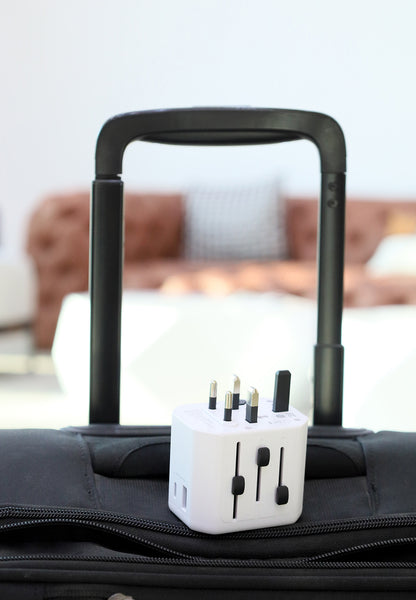 Travel adapter on a suitcase with a blurred indoor background
