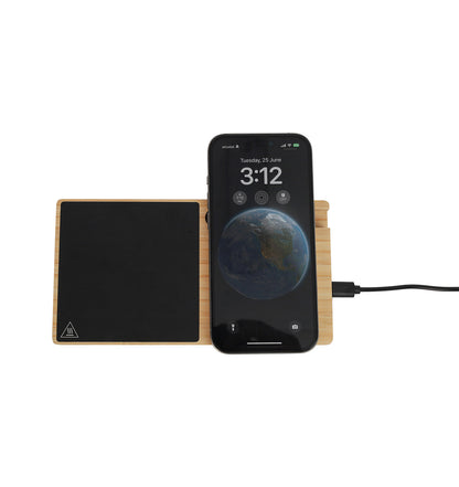 A bamboo wireless charger with a smartphone placed on top of it, indicating the charging function, with a temperature indicator screen on the phone displaying the temperature of the beverage below.