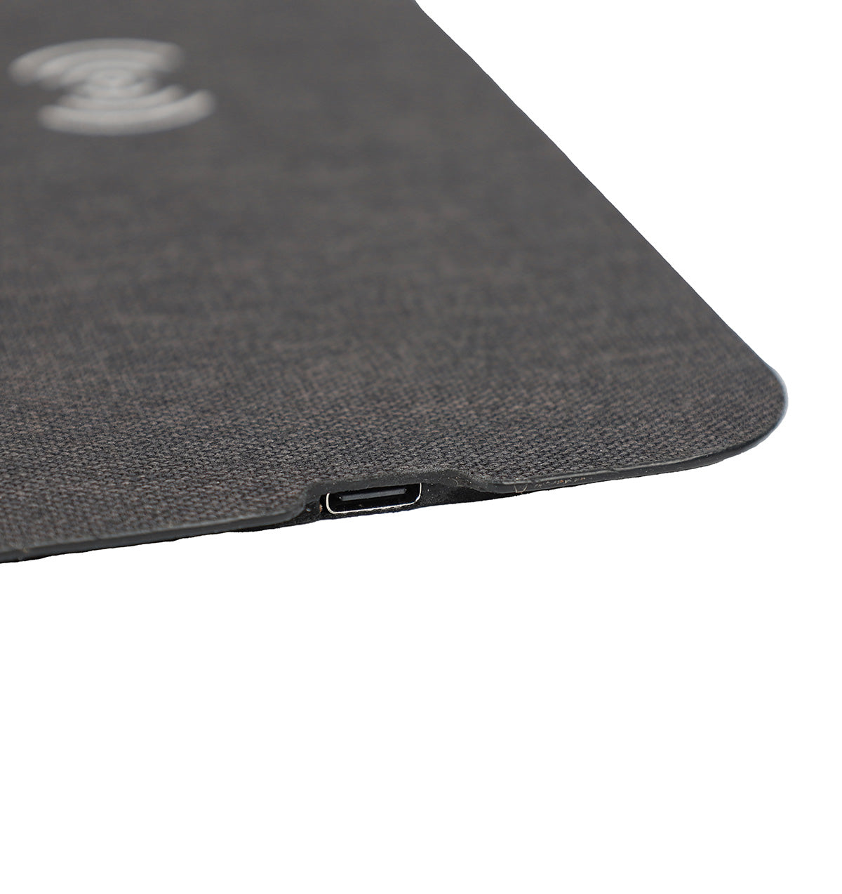 Close-up of a textured black surface with a USB-C port on a white background