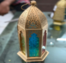 Decorative lantern with intricate design on a reflective surface