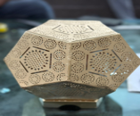 Decorative wooden box with intricate carvings on a reflective surface