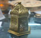 Decorative metal lantern on a reflective surface