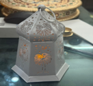 Decorative glass box with intricate design on a reflective surface