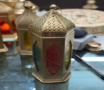 Decorative oil lamp with intricate design on a reflective surface