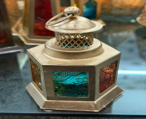 Decorative lantern with colorful glass panels and a small figurine on top.