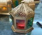 Decorative lantern with a candle inside on a reflective surface