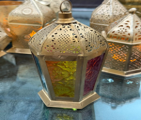 Decorative lanterns with intricate designs on a reflective surface
