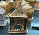 Decorative metal birdhouse on a reflective surface