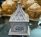 Decorative metal lantern on a reflective surface with blurred background