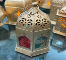 Decorative lantern with intricate designs on a reflective surface