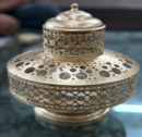Decorative silver bowl with intricate patterns on a reflective surface