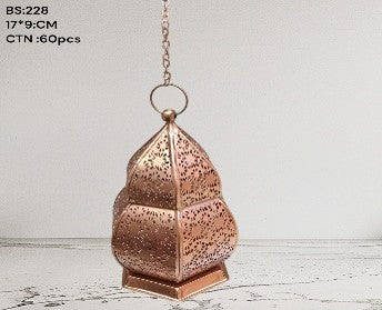 Copper lantern with intricate design on a light wooden surface