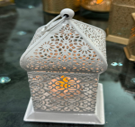 Decorative lantern with intricate designs on a reflective surface