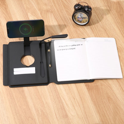 Black stationery set with open notebook, pen, and phone on a wooden surface.