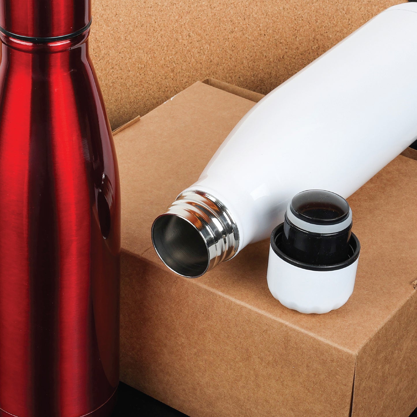 Red and white thermos bottles on a cardboard box